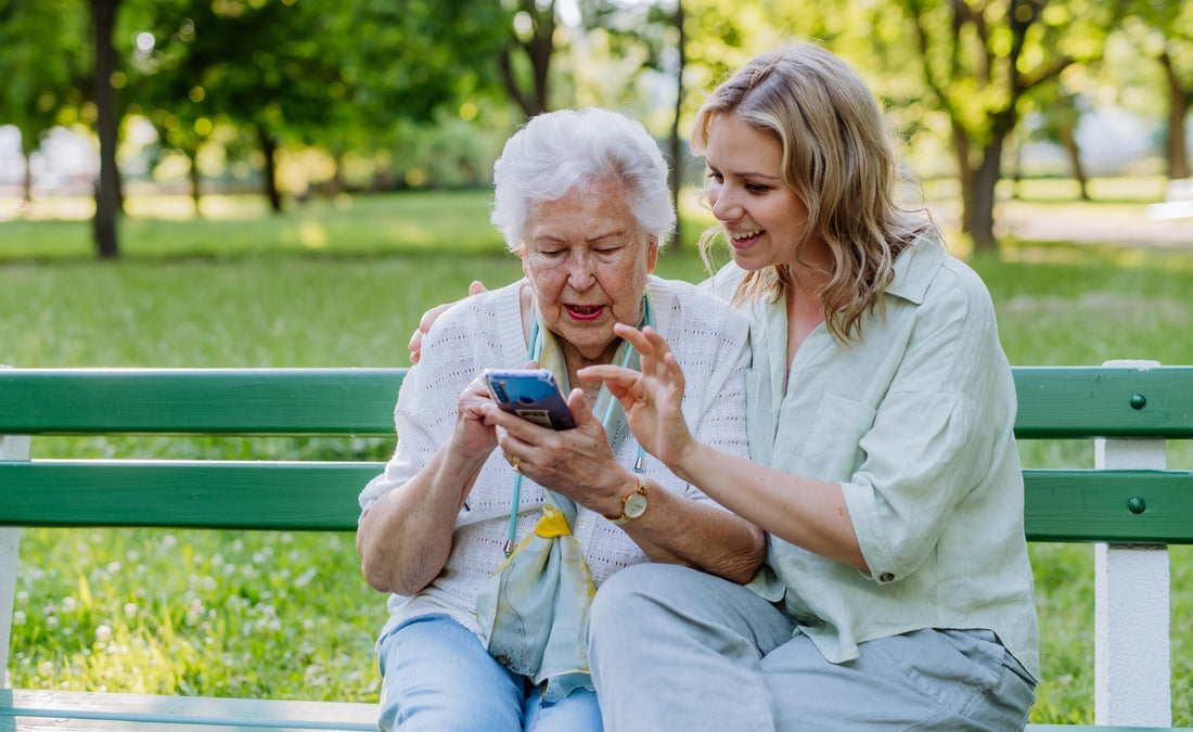 Frau hilft Oma bei Seniorenhandy mit Whatsapp